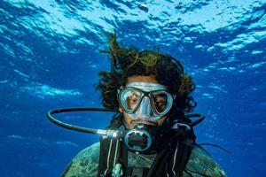 Scuba Diver sonriendo retrato selfie bajo el agua en el océano foto