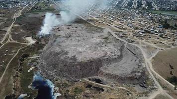 Drone flying over a smoking city dump. Cars in the landfill. video