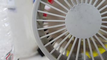 A mini portable fan was running, the fan inside was spinning fast. This portable fan is white. video