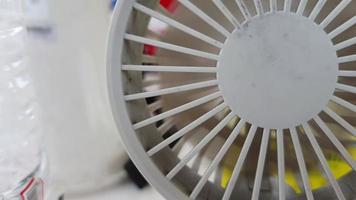 A mini portable fan was running, the fan inside was spinning fast. This portable fan is white. video