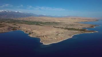 panorámico puntos de vista de el montañas y lago issyk kul en Kirguistán, aéreo video