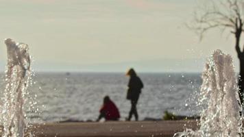 Two Woman Friend and Sephia Winter Beach with Fountain Water Drops Splash