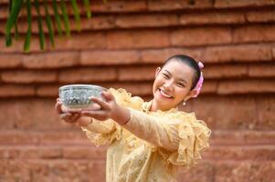 retrato hermosa mujer en el festival de songkran con traje tradicional tailandés foto