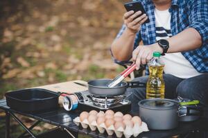 Asian traveler man glasses frying a tasty fried egg photo