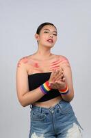 Portrait young asian woman in concept LGBQ with wristband on white background photo