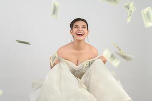 Young asian beautiful bride holding dollar bills in hand photo