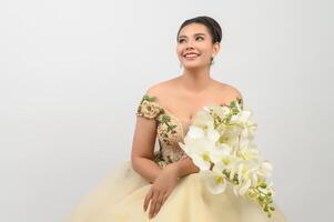 Young asian beautiful bride with orchid bouquet on white background photo