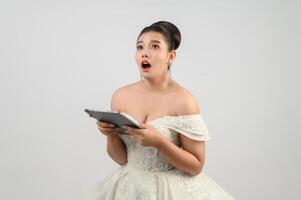 Young asian beautiful bride pose with tablet in hand photo