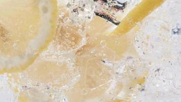 Soda water with ice cubes and sliced lemon slow motion video. video