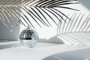 bola de discoteca a la luz del sol sobre fondo blanco foto