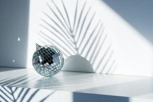 Disco ball in sunlight on white background photo