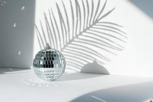 Disco ball in sunlight on white background photo