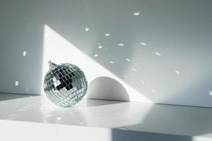 bola de discoteca a la luz del sol sobre fondo blanco foto