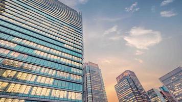 vista de lapso de tempo do céu crepuscular olhando para o prédio de escritórios moderno. conceito de negócios, corporativo e financeiro. video