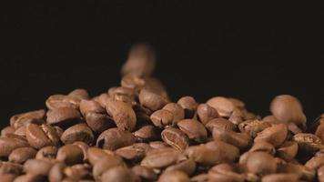 cámara lenta de granos de café tostados cayendo. semillas de café orgánico.