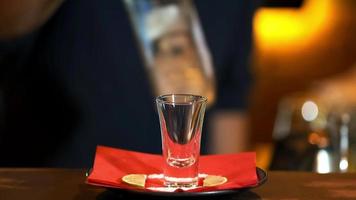 el barman vierte un movido bebida dentro un vaso desde un botella. de cerca. preparación de cócteles y bebidas en el Club nocturno. video