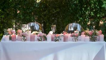 belas decorado romântico feriado mesa com Rosa flores e queimando velas. video
