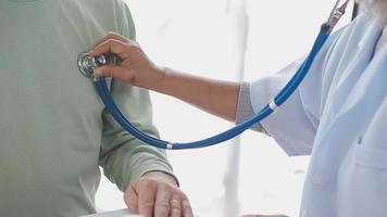 Close up of Female Doctor using stethoscope putting beat heart diagnose with patient in examination room at a hospital, check-up body, Medical and Health Care Concept. video