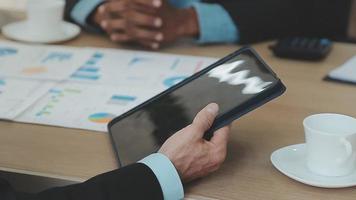 Financial analysts analyze business financial reports on a digital tablet planning investment project during a discussion at a meeting of corporate showing the results of their successful teamwork. video