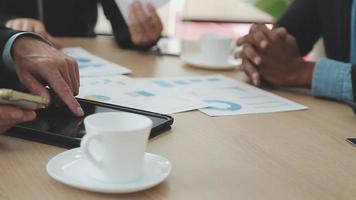 Financial analysts analyze business financial reports on a digital tablet planning investment project during a discussion at a meeting of corporate showing the results of their successful teamwork. video