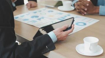 Financial analysts analyze business financial reports on a digital tablet planning investment project during a discussion at a meeting of corporate showing the results of their successful teamwork. video