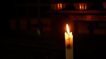 close up minimal view to the candle stick with fire light for praying blessed wish in dark room video