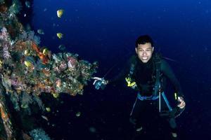 Scuba diver with no mask underwater in the ocean photo