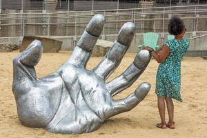 OXON HILL, MD - JUNE 19, 2015 Awakening Sculpture at National Harbor on August 24, 2013 at Oxon Hill, MD USA. A famous 70-foot statue of a giant embedded in the earth created by J. Seward Johnson Jr. photo