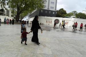 MALE, MALDIVES - FEBRUARY 16 2019 - People and children in island main place before evening pray time photo