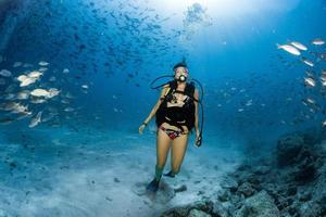 Beaytiful Latina Diver Inside a school of fish photo