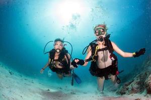 beautiful girls looking at you while swimming underwater photo