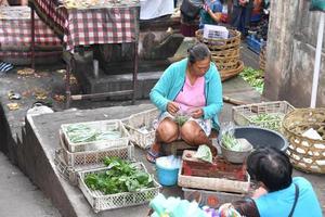 ubud, indonesia - 18 de agosto de 2016 - gente local de la isla de bali vendiendo y comprando en el mercado de la ciudad foto