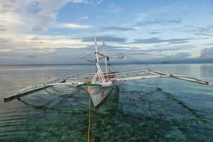 a boat in a tropical paradise beach sunrise photo