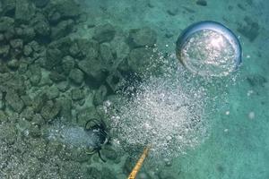 diver bubbles near boat rope underwater photo