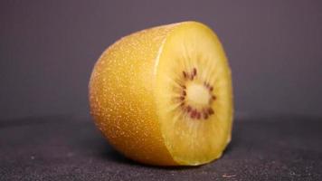 Golden kiwi on a black background rotates video