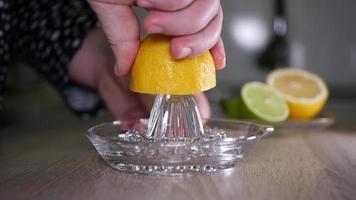 Squeeze the juice of a lemon close-up with a glass squeezer video