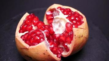 Ripe pomegranate filmed on video against a black background