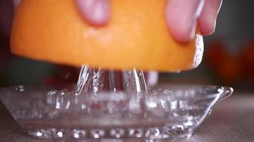 Squeeze grapefruit juice close-up with a glass squeezer video