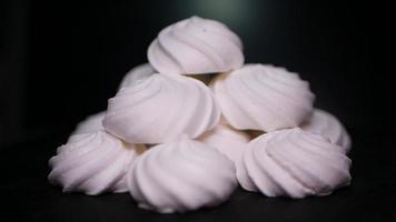 dulces merengue remolinos en un negro antecedentes video