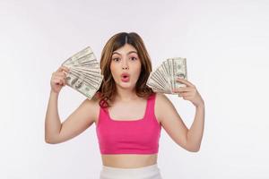retrato de una joven emocionada sosteniendo un montón de billetes de dólares aislados sobre fondo blanco foto