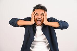 retrato de un joven asiático decepcionado con camisa azul molesto enojado con un gesto furioso aislado de fondo blanco foto