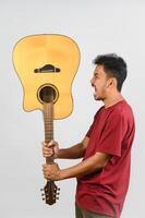 Portrait of Young Asian man in red t-shirt with an acoustic guitar isolated on white background photo