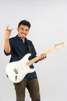 Portrait of Young Asian man in blue shirt with electronic guitar isolated on white background photo