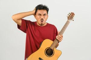 Portrait of Young Asian man in red t-shirt with an acoustic guitar isolated on white background photo