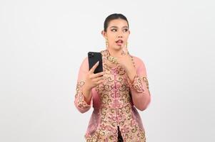 Young beautiful woman dress up in local culture in southern region pose with smartphone photo