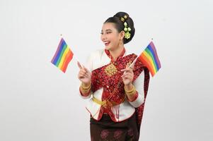 Portrait of Young woman in Thai Northeastern Traditional Clothing holding rainbow flag photo