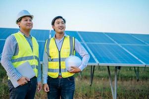 Two young Asian engineers standing at solar farm