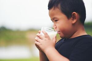 Little boy drinking milk in the park photo