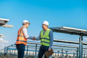 Two engineers are shaking hands at solar farm