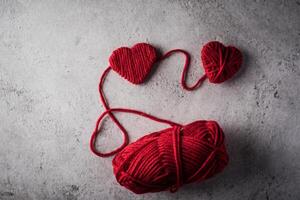 photo red yarn heart shaped on the wall background